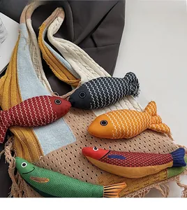 Detail view of colorful knit tote bag with tassel fringe and fish fabric charms