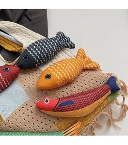 Close-up of fish-shaped fabric charms with wave patterns on a knitted tote bag