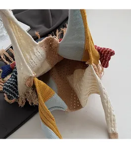 Close-up of multicolored knit tote bag featuring fringe details and open compartment
