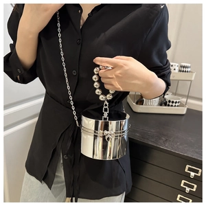 Bolso de fiesta cilíndrico plateado con asa de perlas y cadena mostrado por modelo