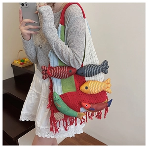 Detail of colorful knitted bucket bag with 3D fish dolls and red fringe tassels