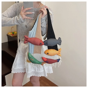 Detail of colorful knitted bucket bag with fish charms and fringe trim accents