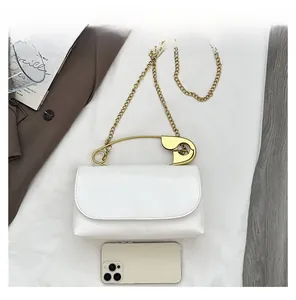 Vue détaillée du sac bandoulière blanc avec poignée épingle dorée et comparaison de taille