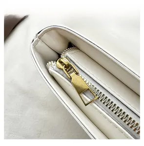 Vue macro de la fermeture éclair en métal doré et des coutures sur le sac blanc