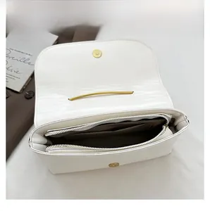 Détail de l'intérieur du sac à bandoulière blanc avec poche zippée et fermoir magnétique doré