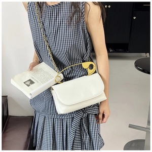 Détail d'un sac bandoulière en similicuir blanc avec poignée épingle de sûreté dorée