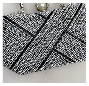 Detailed view of luxury evening clutch with silver pearls and black rhinestone stripes