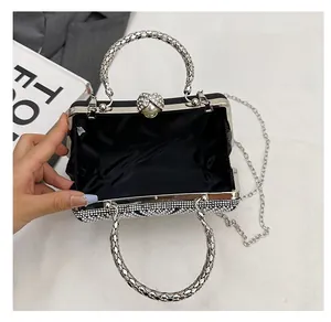 Detail of evening clutch featuring rhinestone exterior and heart-shaped pearl clasp