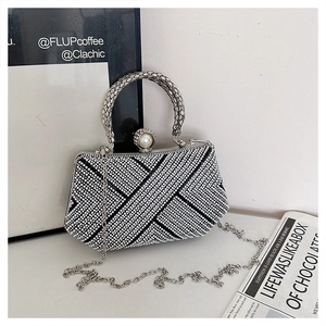 Detail of luxury geometric evening bag with pearl clasp and snake bone metal handle