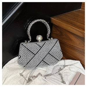 Detail of silver evening bag featuring geometric rhinestones and a large pearl clasp