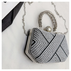 Macro shot of silver geometric evening bag with V-pattern rhinestones and pearls
