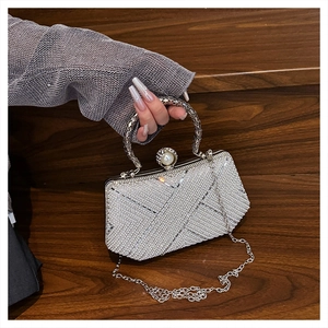 Detail of luxury white pearl evening bag with rhinestone patterns and metal ring handle