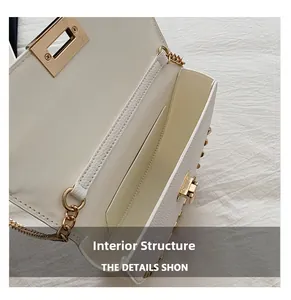 Detail view of the white pebble leather bag interior with gold hardware and inner pocket