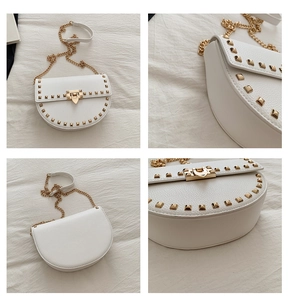 Detail view of white saddle bag showing gold rivets, texture, and chain strap