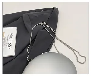 Detailed close-up of a silver round hardshell bag featuring a sleek snake chain strap