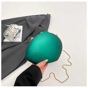 Detail of emerald green oval acrylic evening clutch bag with gold snake chain