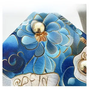 Macro detail of Chinese style butterfly embroidery fabric and gold metal button decoration