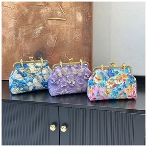 Detail of 3D embossed floral and butterfly patterns on retro shell evening bags