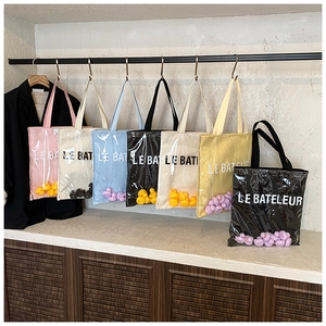 Detailed close-up of colorful jelly tote bags with cute duck dolls and PVC layering