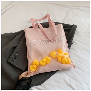 Close-up of clear PVC tote with yellow rubber ducks and pink inner fabric pocket