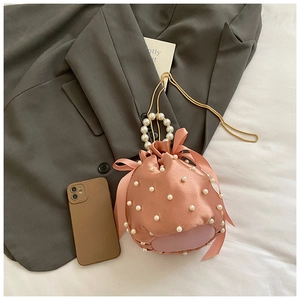 Pink satin drawstring bucket bag with pearl embellishments and golden chain strap