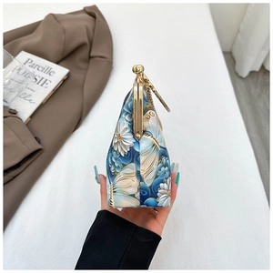 Side view of floral butterfly embroidery shell bag with golden kiss-lock and chain strap