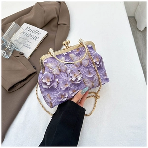 Detail view of purple butterfly embroidery on a shell bag with a gold chain strap