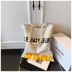 Detailed shot of transparent PVC tote bag with canvas inner pouch and yellow rubber ducks