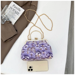 Size comparison of purple floral embroidered shell bag with a smartphone reference