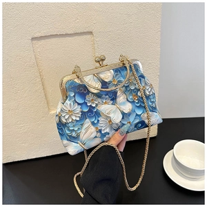 Detail of embroidered butterfly bag with floral patterns and gold metal frame