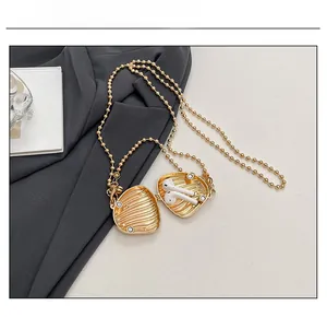 Golden shell necklace pendant storage case showing space for wireless earphones