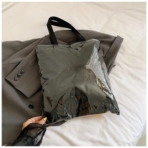 Detail of transparent PVC tote bag with black inner pouch and wide shoulder straps