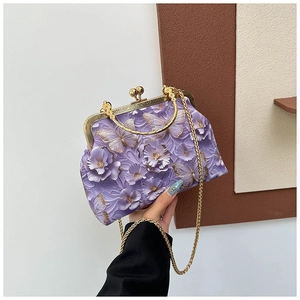 Detail of purple embroidery handbag with embossed floral butterfly patterns and gold clasp