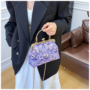 Detail of purple embossed shell bag with gold hardware and butterfly floral patterns