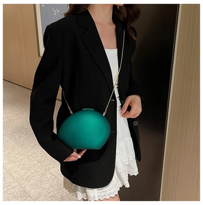 Deep green pebble-shaped acrylic evening clutch bag with fine gold chain strap
