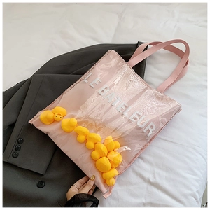 Detail of pink jelly tote bag with interior yellow ducklings and Le Bateleur text