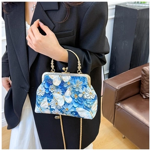 Detail of vintage blue shell bag with butterfly embroidery and golden bead handle
