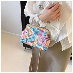 Detailed view of 3D butterfly embroidery and golden metal frame on shell handbag