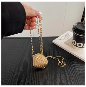 Detailed view of mini golden shell-shaped chain bag with elegant pleated texture