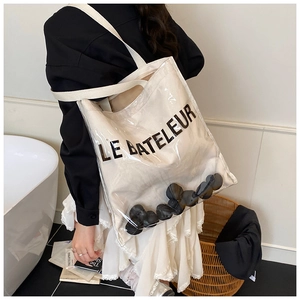 Detail of transparent PVC tote bag with white canvas inner and Le Bateleur logo