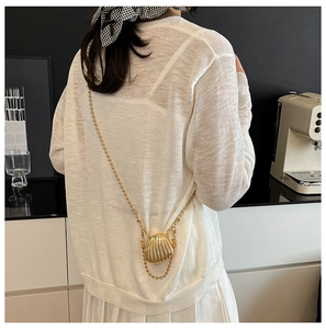 Detailed back view of a mini golden shell crossbody bag with a delicate metallic ball chain