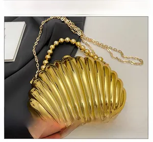 Detail view of golden shell evening bag featuring textured surface and beaded handle