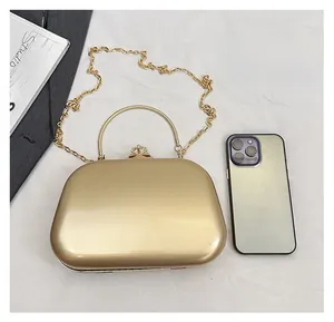 Size comparison of a gold metallic evening clutch bag next to a smartphone