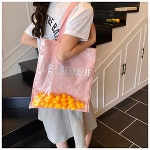 Detail of pink canvas tote with PVC layer filled with mini yellow duck toys and text