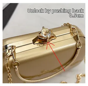 Detail of gold clutch bag crystal clasp with instruction to push back 0.5cm to unlock