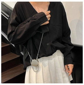 Detailed view of silver shell-shaped mini bag with elegant metallic bead chain
