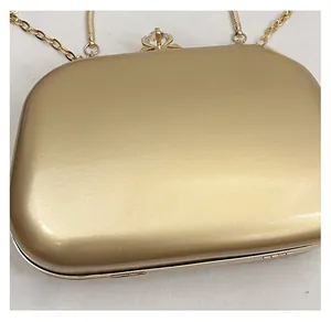 Macro view of gold metal evening clutch with shimmering finish and crystal clasp buckle
