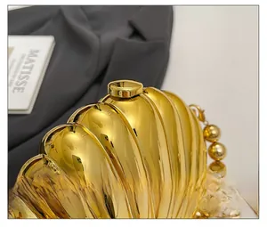 Close-up of golden shell evening clutch with polished metallic finish and hardware clasp