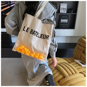 Detail of clear PVC tote with canvas inner bag featuring decorative yellow rubber ducks