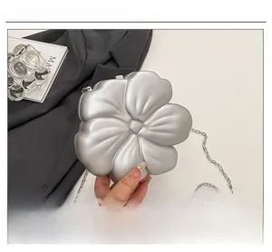 Detailed macro view of the silver 3D flower evening clutch with a metallic chain strap